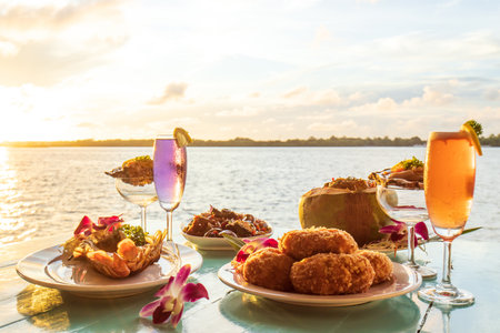 Thai cuisine set, grilled river prawn, catfish curry, curry steamed seafood in a coconut cup, and deep-fried shrimp cake served with wine and raw oysters.の写真素材