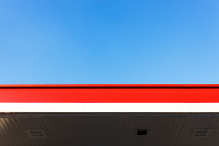 Red and white striped rooftops against a light blue sky in the background on a summer day.の写真素材