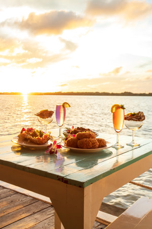 Thai cuisine set, grilled river prawn, catfish curry, curry steamed seafood in a coconut cup, and deep-fried shrimp cake served with wine and raw oysters.の写真素材