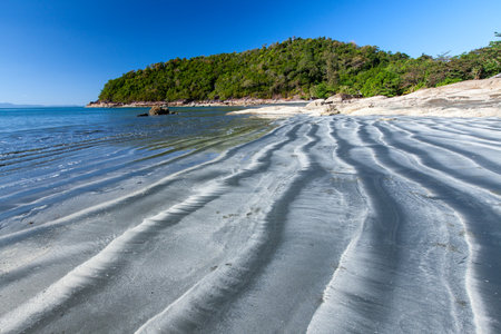 The landscape of the black sand beach on a sunny summer abstracts the ripples and layers on the beach. Koh Chang, Ranong, Thailanの写真素材