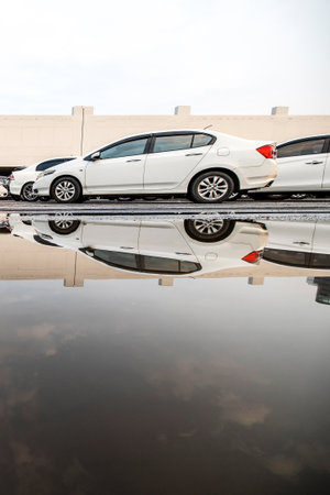 The landscape of cars parked in parking areas, and reflected on the water that flash floods after...