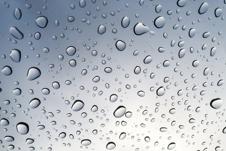 Raindrops on the glass look up to the sky blurred in the background.の写真素材