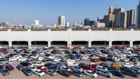 Aerial view of cars parked in parking areas, and skyscrapers in the background.