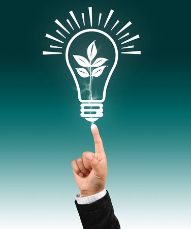 Bulb light with leaf on businessman fingertipの写真素材