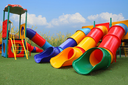 colorful playground park is build happy equipment children on blue sky, flower and grassの写真素材