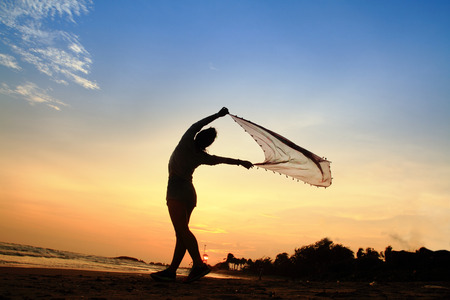 silhouette lifestyle woman pose play cotton on the beach sunsetの写真素材