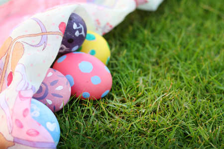 Eggs pastel colors and beautiful fabrics on grass on Easter day.の写真素材