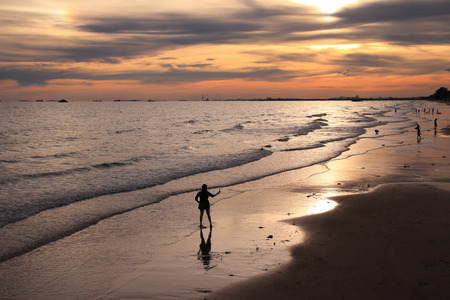 Sunset background and people silhuouette on the beachの写真素材