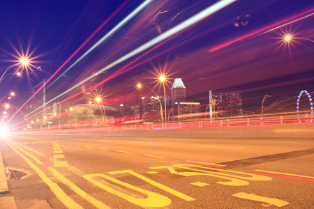 Red Speed lights from bus and cars on a road to cityの写真素材