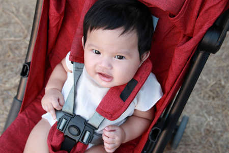 Asian children are smiling happily.On a red stroller.の写真素材
