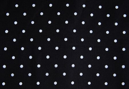 White dot pattern on black fabric background.Abstract pattern fabric.の写真素材