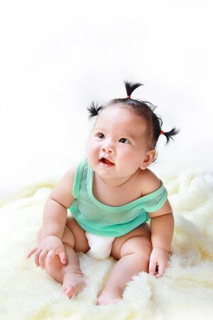 A Baby girl in the light blue dress Laughing happily and looking up isolated on white backgroundの写真素材