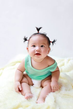 A Baby girl in the light blue dress Laughing happily and looking up isolated on white backgroundの写真素材