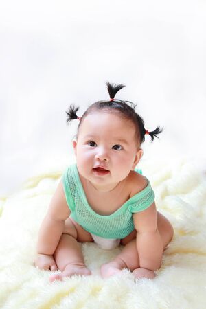 A Baby girl in the light blue dress Laughing happily and looking up isolated on white backgroundの写真素材