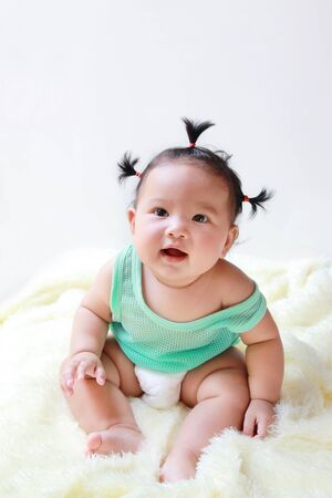 A Baby girl in the light blue dress Laughing happily and looking up isolated on white backgroundの写真素材
