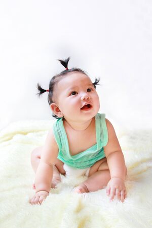A Baby girl in the light blue dress Laughing happily and looking up isolated on white backgroundの写真素材