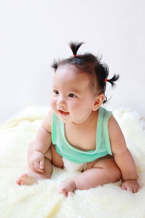 A Baby girl in the light blue dress Laughing happily And look to the left isolated on white backgroundの写真素材