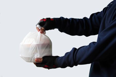 Food service providers sending plastic bags with food to customers who order food online isolated on white background.の写真素材