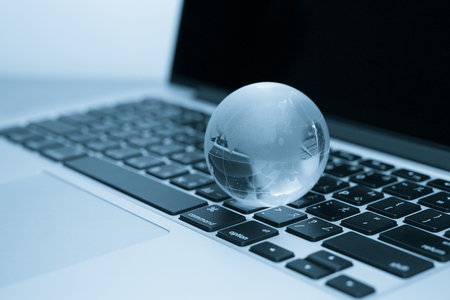 crystal Earth globe on laptop or notebook keyboardの写真素材