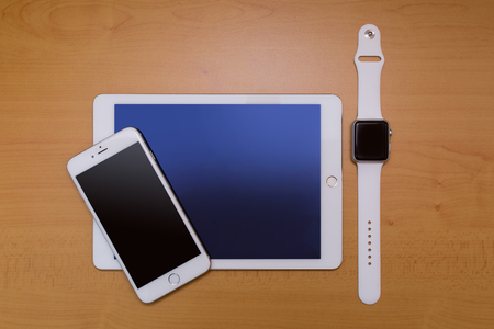 White Smart-phone And Digital tablet And White Smart-watch. On wood desk.の写真素材
