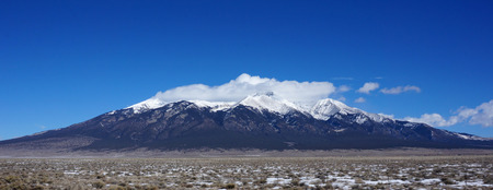 View of mountains in Colorado in winter time. Top of the mountain is being covered by the white snow.の写真素材