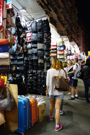 HONG KONG - NOVEMBER 22 :Tourists shop for bargain priced fashion and casual wear in Mong Kong night market on 22 November 2014. The busy night market is famous with many booths setting up to sell local products.のeditorial素材