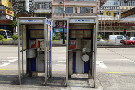 HONG KONG - NOV 21: Two phone booths locate in Mong Kok on November 21, 2014 in Hong Kong, China. As cell phone getting more popular, phone booth is rarely seen in Hong Kong today.のeditorial素材