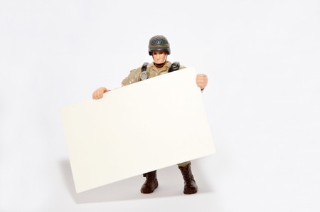 Soldier holds a namecard with isolated white backgroundの写真素材