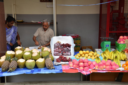 SINGAPORE - NOV 07, 2015: Unknown indian sales a coconuts on a street in Little India, Singapore.のeditorial素材