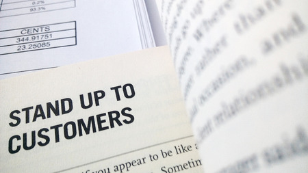 Stand up to customers word on the book with balance sheet as backgroundの写真素材