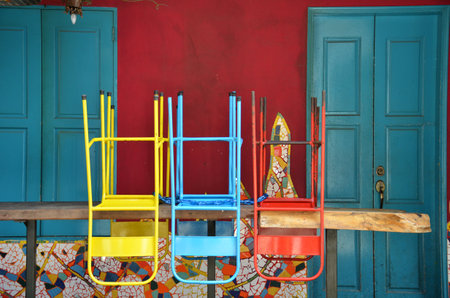 Colorful chairs on a wooden table in front of old shop, Singaporeのeditorial素材