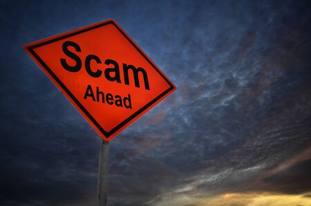 Scam ahead warning road sign with storm backgroundの写真素材