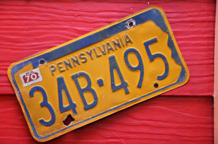 BANGKOK, THAILAND-20 JUNE, 2016:  Yellow license plate of Pennsylvania, America on red wood background at Chocolate Ville Park.のeditorial素材