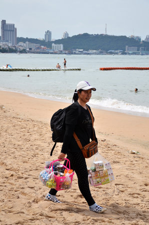 PATTAYA, THAILAND - 22 NOV, 2016: Local merchant selling souvenirs to tourists at Pattaya beachのeditorial素材