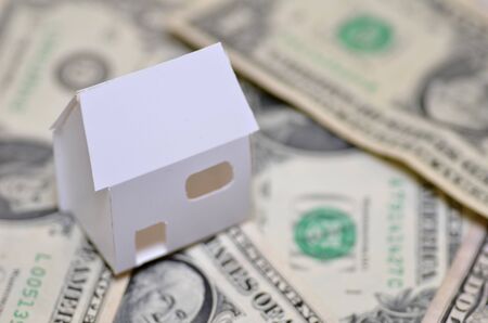 Paper made house stands on dollar moneyの写真素材