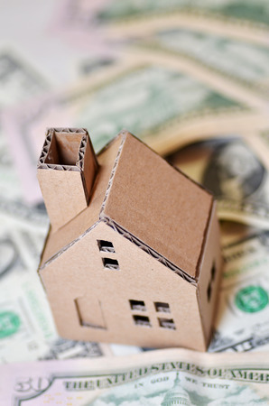 Paper made house stands on dollar moneyの写真素材