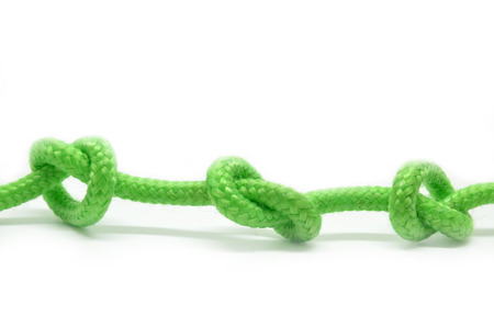 Three tied knots on green rope, isolatedの写真素材