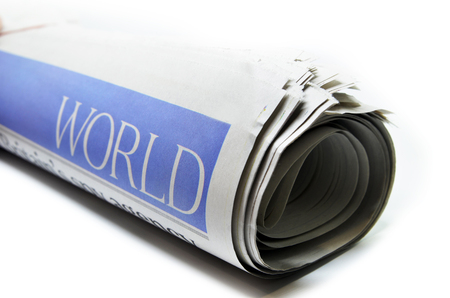Rolled newspaper with the headline world newsの写真素材