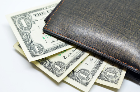 Money sticking out of a leather wallet, isolated on whiteの写真素材