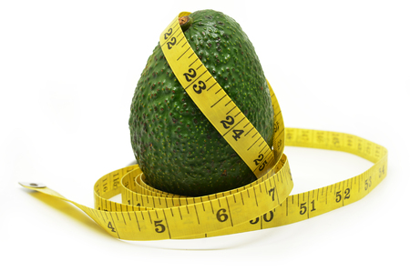 Avocado with measuring tape isolated on whiteの写真素材