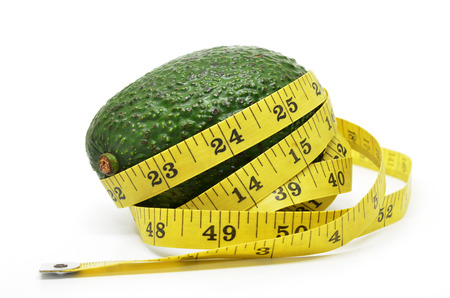 Avocado with measuring tape isolated on whiteの写真素材