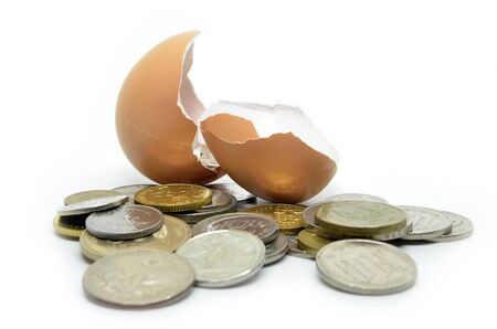 Cracked egg shell and coins isolated on white
