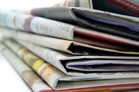 Newspapers folded and stacked isolated on white