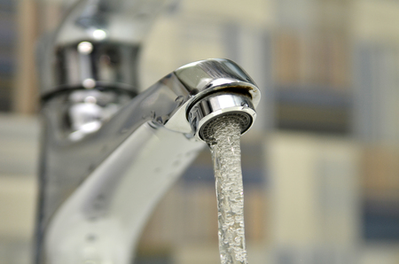 Opened water tap in the washroom. Save water concept