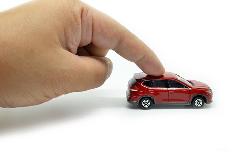 The finger of the businessman moves the toy carの写真素材