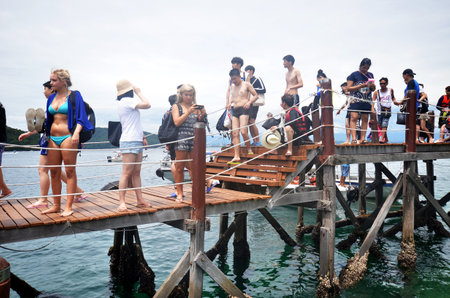 KOTA KINABALU, MALAYSIA- 24 JUN 2017: Tourists walk on Manukan Island footbridge in Malaysia. The Manukan Island Resort is a hideaway that is one of the five tropical islands that comprise the Tunku Abdul Rahman Park.のeditorial素材