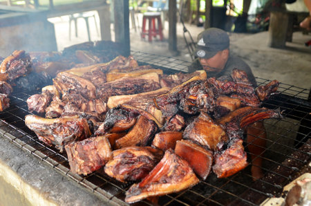 KOTA KINABALU, MALAYSIA- 24 JUN 2017: Vendor prepares Sinalau Bakas on the road side stall. Sinalau Bakas is a native Borneo food. Smoked wild boarのeditorial素材