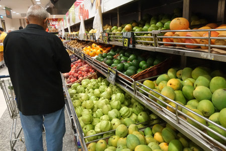 SINGAPORE- NOV 11, 2017: Unidentified man buy local fruits from a rack in a shop in Singapore.のeditorial素材