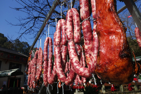 The suspended pieces of the meat drying outside on the sunの写真素材