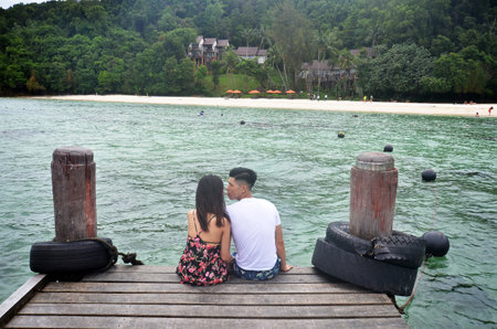 KOTA KINABALU, MALAYSIA- 29 JUN, 2017: Couple sit on the jetty at Manukan Island in Sabah. Manukan Island is the most visited island by tourists.のeditorial素材